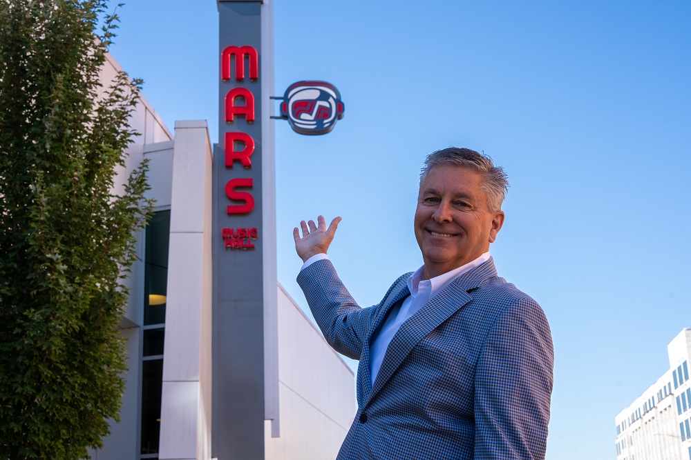 Mike Vojticek in front of VBC Mars Music Hall sign