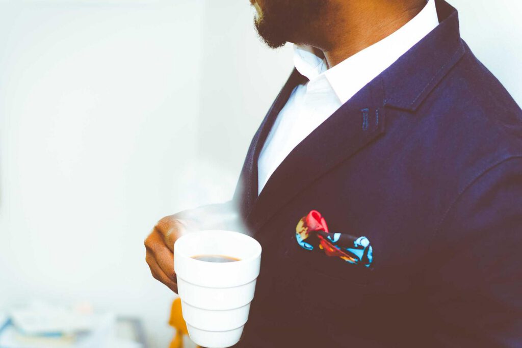 Closeup image of a man holding a steaming coffee cup