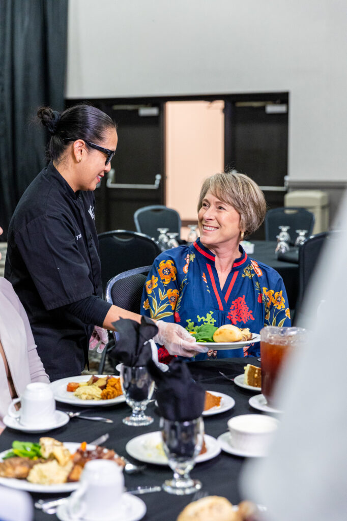 Image of a waitress serving a guest her meal