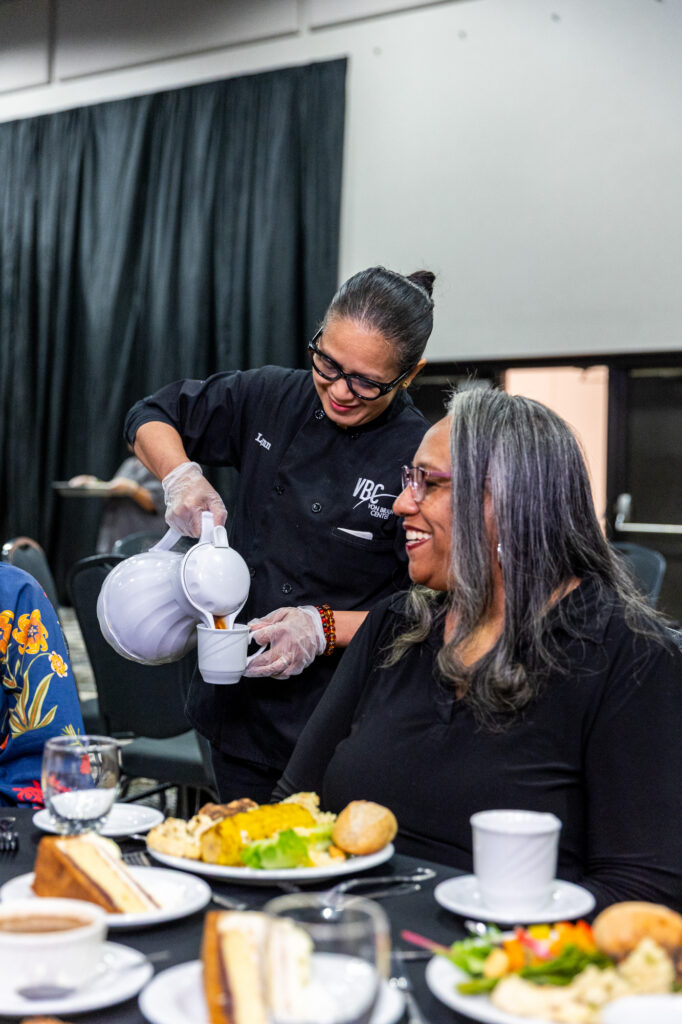 Image of a serving pouring coffee for a guest at a banquet table