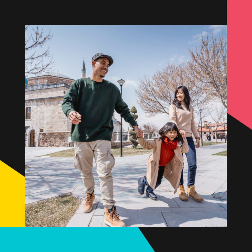 Photo of parents holding hands with their daughter