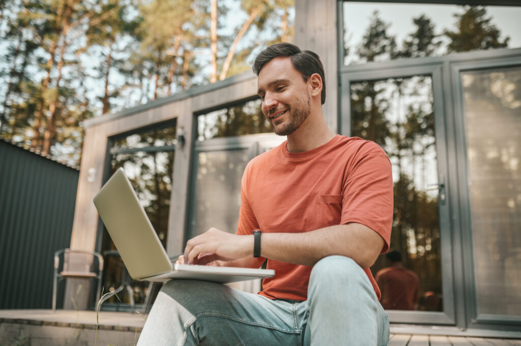 Image of a man smiling at his laptop