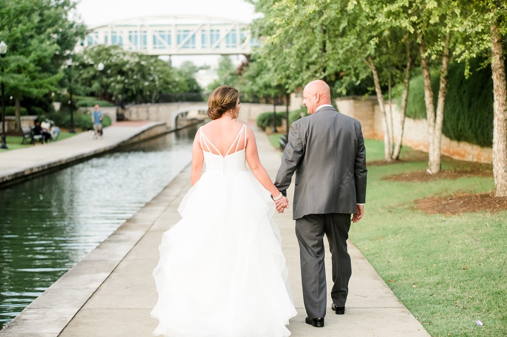 Photo of bride and groom walking towards skybridge connecting to VBC