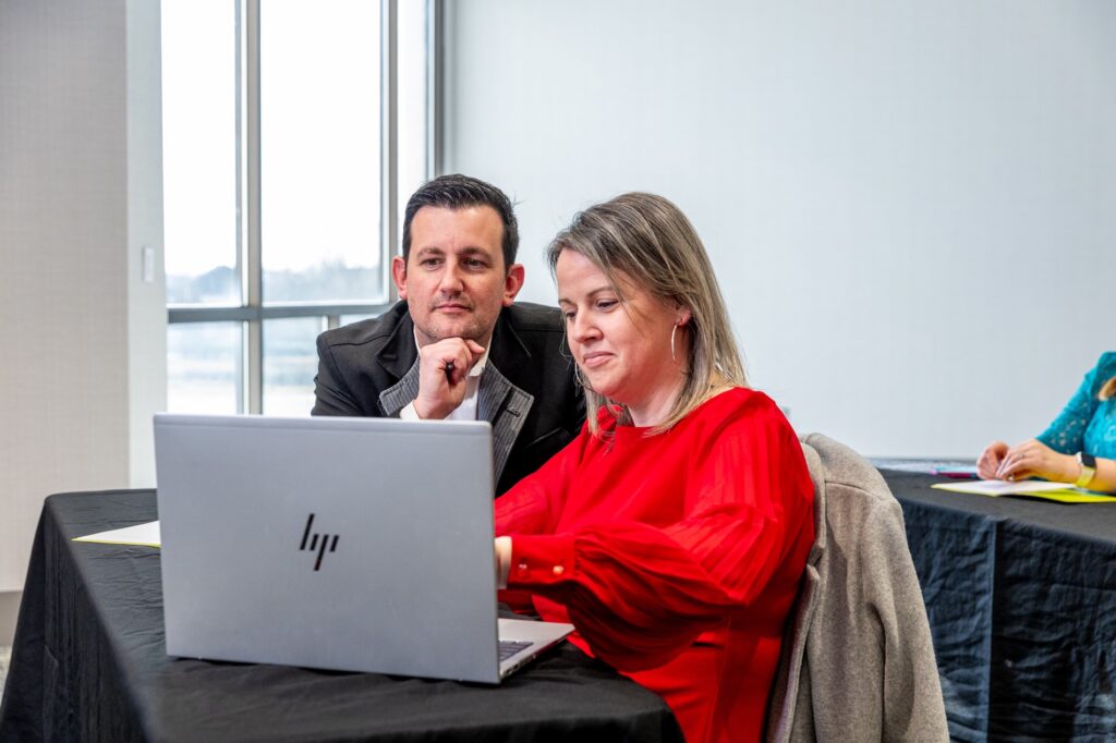 Image of guests looking at a laptop during a meeting