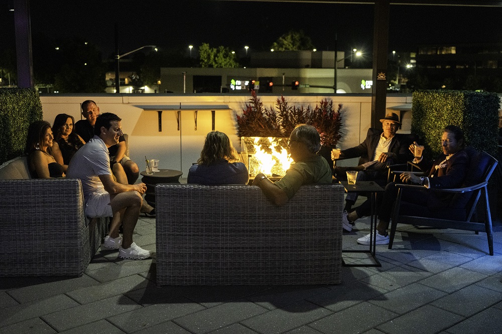 Photo of guests sitting by firepit on Rhythm On Monroe's rooftop