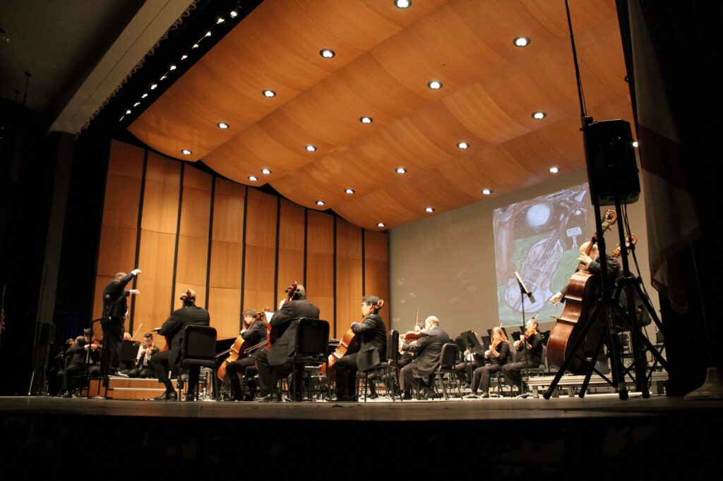 Photo of HSO practicing with onscreen video projection