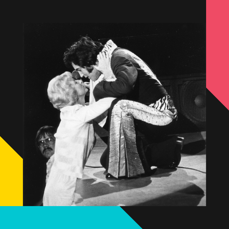 Photo of Elvis giving a scarf to a fan during one of his performances at the VBCC arena
