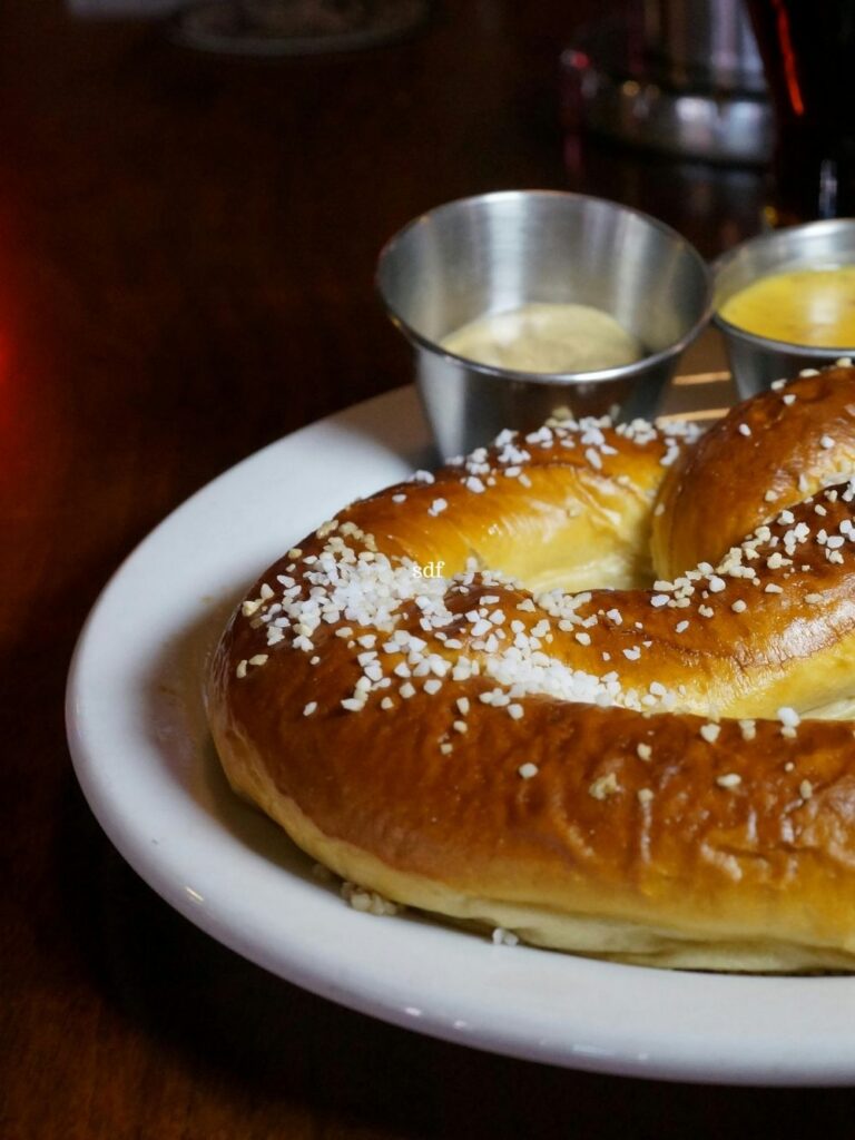 Photo of salted, soft baked pretzel served with spicy mustard